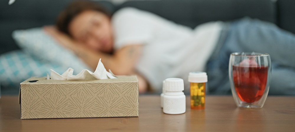 Table with cold medication in front of a person lying down